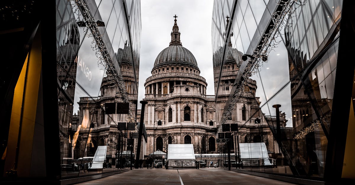 View of St. Paul's Cathedral framed by modern glass structures, creating a striking urban reflection.